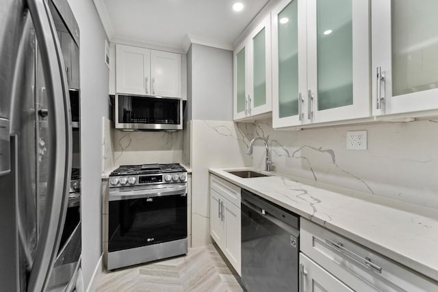 kitchen featuring sink, white cabinets, light parquet floors, stainless steel appliances, and light stone countertops