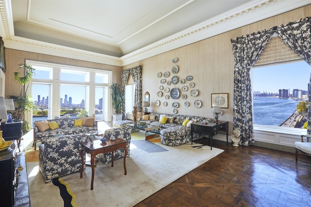 living room with a tray ceiling, plenty of natural light, and dark parquet flooring