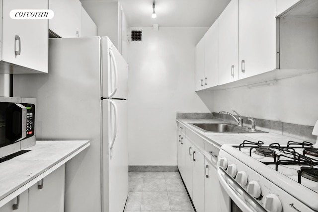 kitchen with white appliances, light countertops, visible vents, and a sink