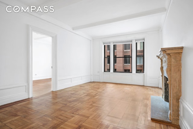 unfurnished living room featuring a decorative wall and beamed ceiling