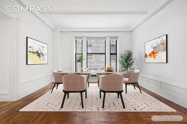 dining area featuring a decorative wall and a wainscoted wall