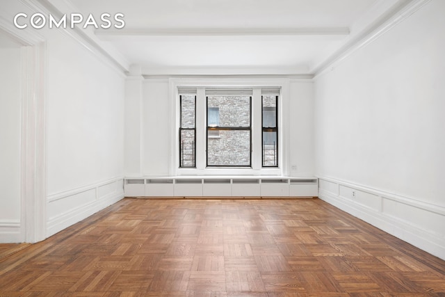 spare room with a decorative wall and wainscoting