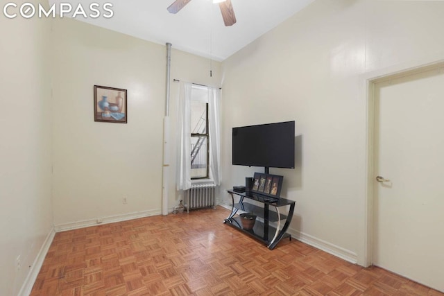 living room with ceiling fan, light parquet floors, and radiator