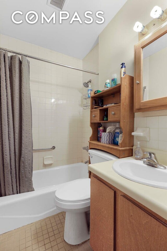 full bathroom with toilet, decorative backsplash, tile patterned flooring, shower / tub combo, and vanity