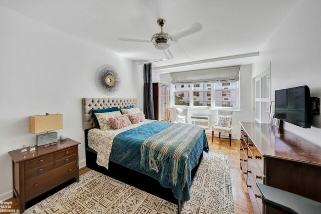 bedroom featuring an AC wall unit, ceiling fan, and light wood-type flooring