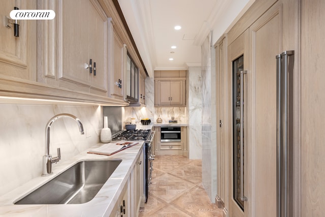 kitchen featuring ornamental molding, appliances with stainless steel finishes, light brown cabinetry, and sink