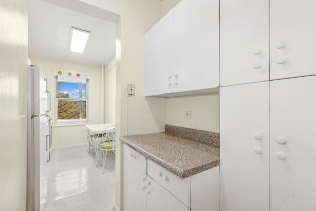 kitchen featuring white cabinetry and white refrigerator