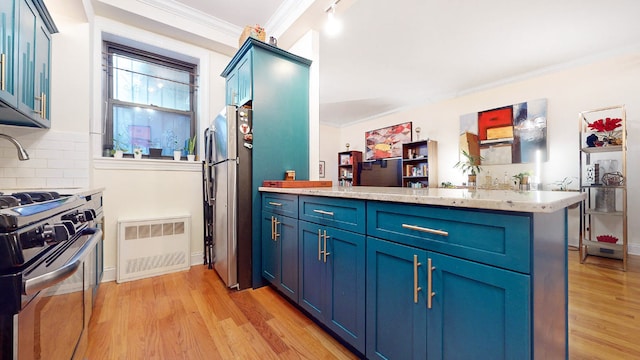 kitchen featuring tasteful backsplash, kitchen peninsula, and blue cabinets