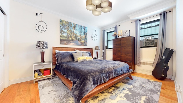 bedroom with ornamental molding, cooling unit, and light wood-type flooring