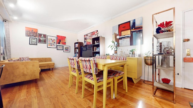 dining room with crown molding and light wood-type flooring