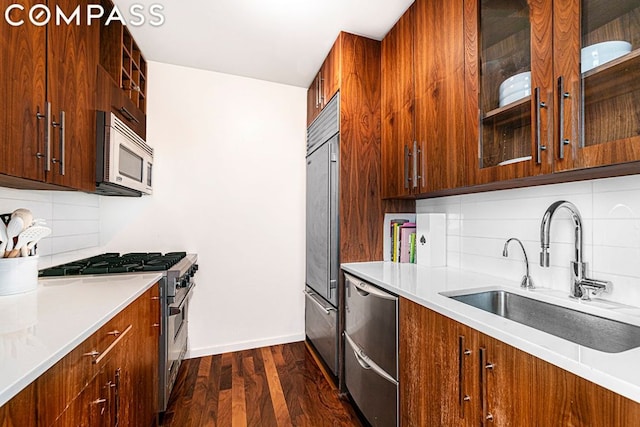 kitchen with decorative backsplash, sink, dark hardwood / wood-style flooring, and high quality appliances