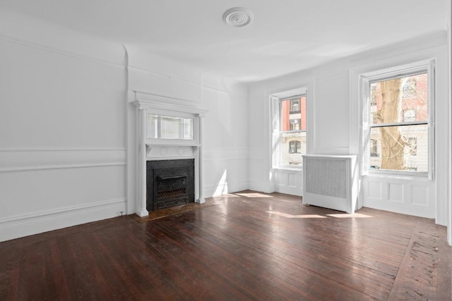 unfurnished living room with hardwood / wood-style floors and radiator heating unit