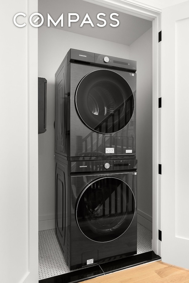 washroom featuring baseboards and stacked washer / drying machine