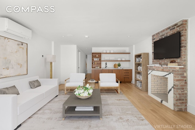 living area with a brick fireplace, a wall mounted air conditioner, and light wood-style flooring