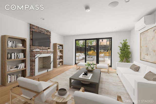 living area with light wood-type flooring, a brick fireplace, and an AC wall unit