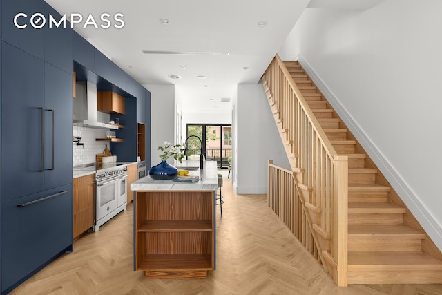 kitchen featuring open shelves, wall chimney range hood, modern cabinets, and premium appliances