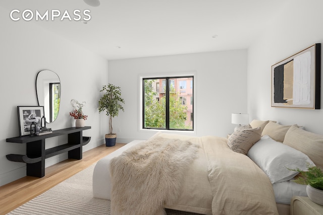 bedroom with baseboards and wood finished floors