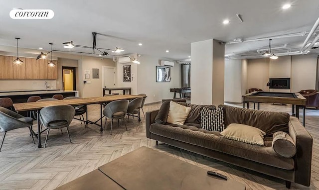 living area with recessed lighting, visible vents, and a wall unit AC