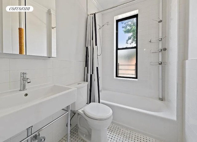 bathroom featuring a sink, shower / tub combo, and toilet