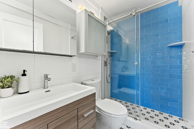 bathroom with tile walls, vanity, decorative backsplash, toilet, and walk in shower