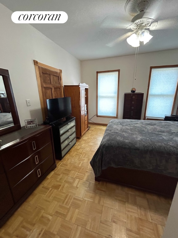 bedroom featuring light parquet floors, a textured ceiling, and ceiling fan