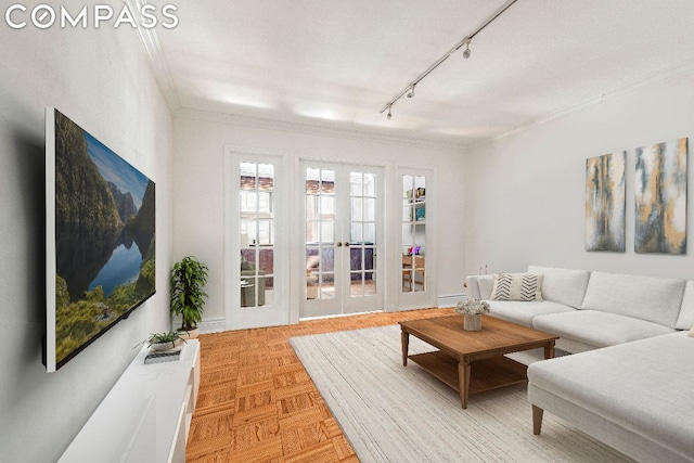 living room featuring rail lighting, ornamental molding, french doors, and light parquet floors