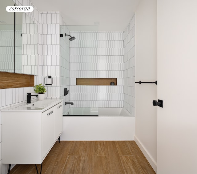 full bathroom featuring washtub / shower combination, wood finished floors, and vanity
