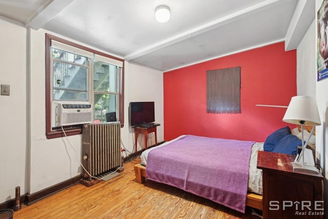 bedroom featuring radiator, vaulted ceiling, cooling unit, and wood-type flooring