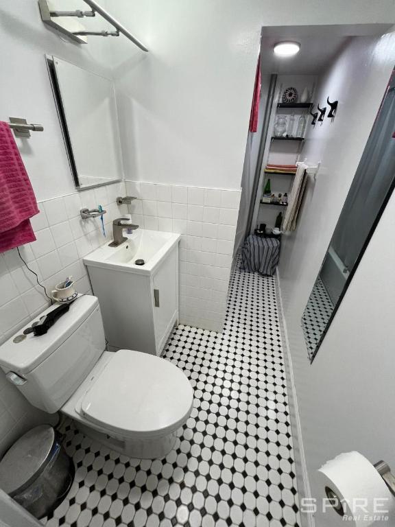 bathroom with toilet, tile walls, tile patterned floors, and vanity