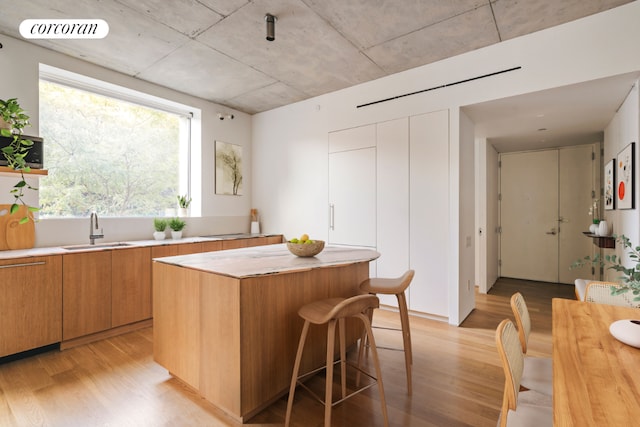 kitchen featuring sink, a center island, and light hardwood / wood-style flooring