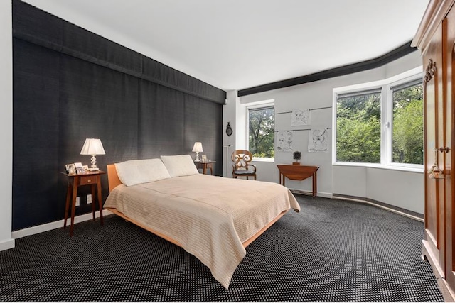 bedroom featuring baseboards and dark carpet