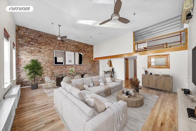 dining area with ceiling fan, brick wall, and light hardwood / wood-style flooring