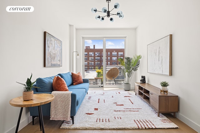 living room featuring visible vents, baseboards, an inviting chandelier, and wood finished floors