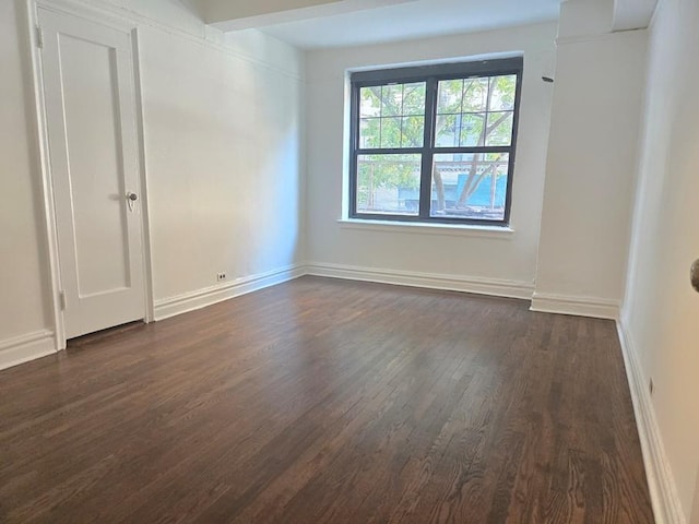 unfurnished room with dark hardwood / wood-style flooring