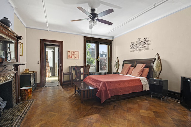 bedroom featuring ceiling fan, ornamental molding, and a fireplace