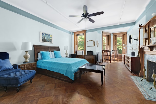 bedroom featuring rail lighting, multiple windows, and a fireplace