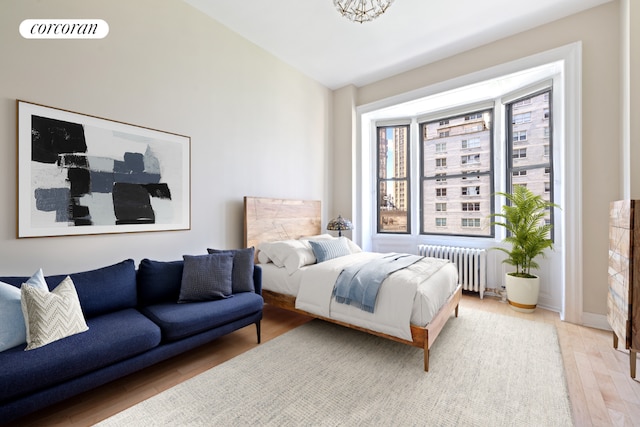 bedroom featuring hardwood / wood-style flooring and radiator heating unit