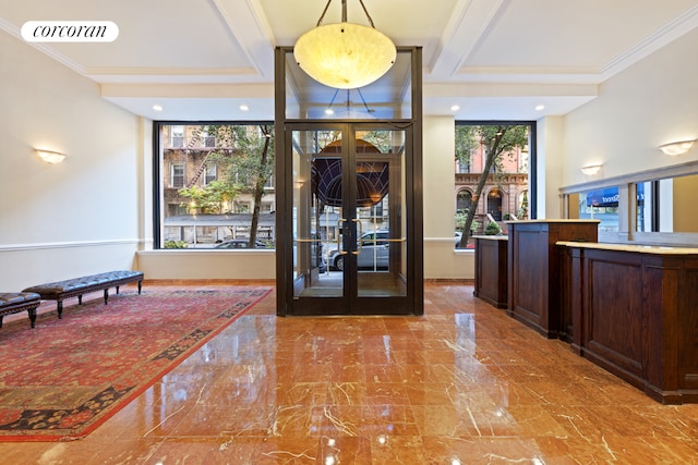 entryway with crown molding and french doors