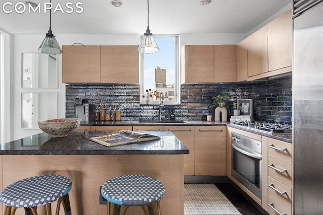 kitchen featuring pendant lighting, sink, a breakfast bar area, and appliances with stainless steel finishes