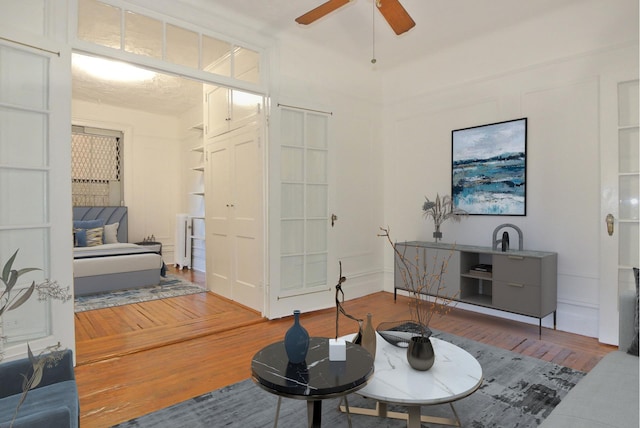 living area with wood finished floors and ceiling fan