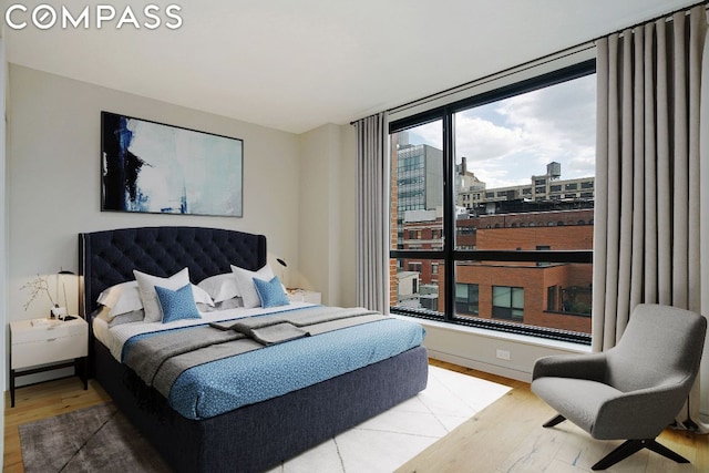 bedroom featuring multiple windows and hardwood / wood-style flooring