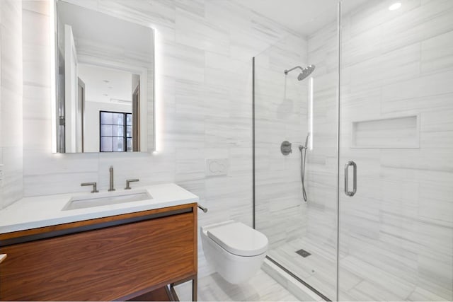 bathroom with a shower with shower door, vanity, tile walls, and toilet