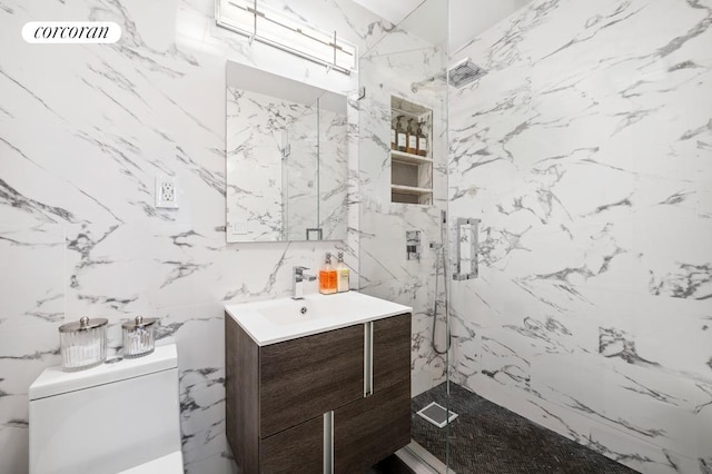 bathroom featuring a shower with shower door, toilet, and vanity