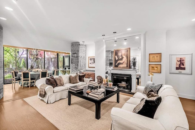 living room featuring recessed lighting, a fireplace, and wood finished floors