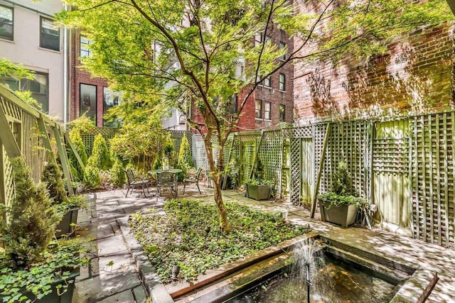 view of yard with a patio, outdoor dining space, and fence