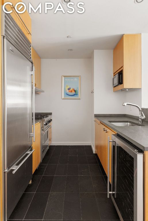 kitchen with sink, premium appliances, and beverage cooler