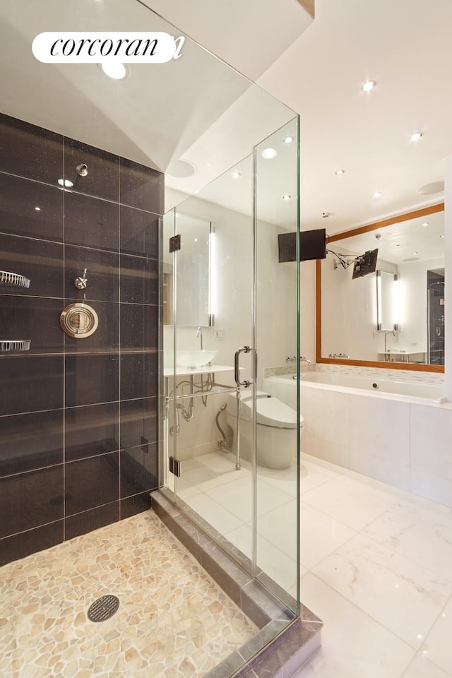 bathroom featuring recessed lighting, a bathing tub, a stall shower, and a sink