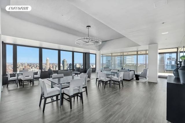 117 E 57th St Unit 25H, New York City, NY 10022 - dining space with wood finished floors, a view of city, and a chandelier