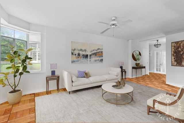 living room featuring baseboards and ceiling fan