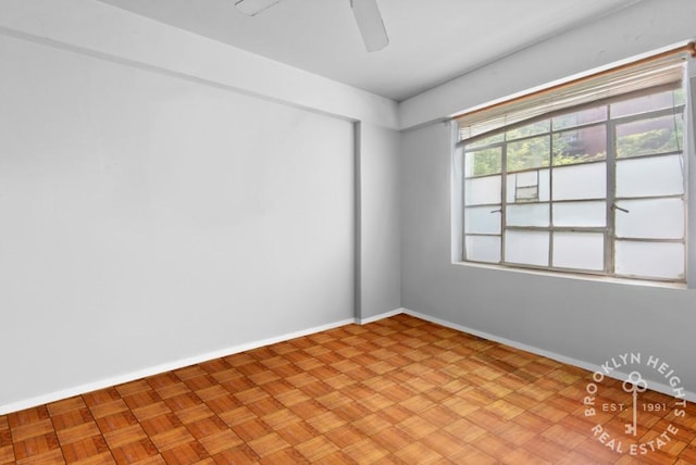 spare room with baseboards and a ceiling fan